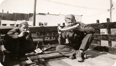 Mose Maggard and another CCC man eating watermelon in the back of a truck. Back of photo reads: 'Mose Maggard 1935'.