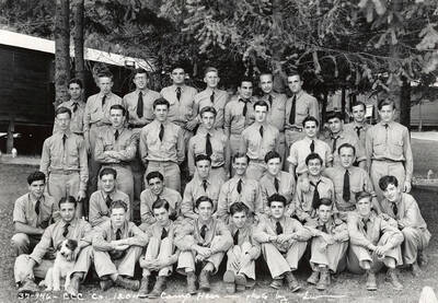 Group of uniformed CCC men posing for a photo with a dog at CCC Camp Hess, F-204, Company 1204. Writing on the photo reads: 'CCC Company 1204 Camp Hess photo by Leo'. Back of photo reads: 'Camp Hess St. Joe'.