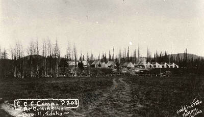 View of CCC Camp Collins, P-208 (also F-141), near Bovill, Idaho. Writing on the photo reads: 'CCC Camp P-208 At Collins Bovill, Idaho Hodgins Foto Moscow, Idaho'. Back of photo reads: 'Clearwater National Forest Collins'.