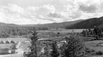 A view of CCC Camp Red River, F-102, Company 573, in the Valley. Back of photo reads: 'Red River Valley 1939 CCC Camp to left. C.J. Porlutner St. Gertrude's Museum Civilian Conservation Corps'.