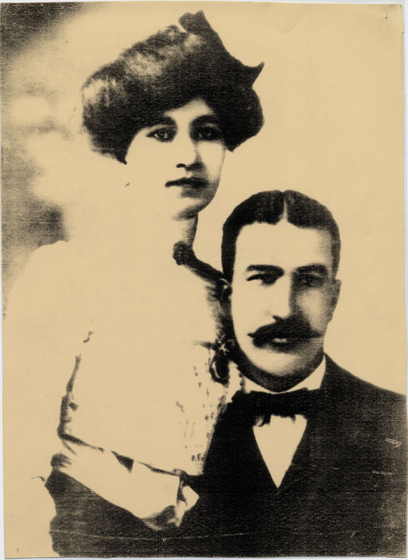 Alice Anthony Cheatham (1876-1959) on the left, standing next to Marshall Nye Cheatham (1869-1942) on the right, who is sitting. Alice wears a high-collar, lace dress and has a poofy hairstyle. Marshall sports an impressive mustache, a bowtie, and a suit jacket. Alice worked as a laboratory technician and teacher, while Marshall owned and operated a whites-only barber called "Cheatham and Bibb's Barber Shop," in Nashville, Tennessee (I Guess I'll Get the Papers and Go Home pg 1). The couple would go on to have two sons, Marshall Nye Cheatham Jr. (1903-1978), and Doc Cheatham. The back of the picture has "Estate of Doc Cheatham - Printed From Doc's Book." The picture has four small holes poked through the corners, such as those made by thumbtacks. 