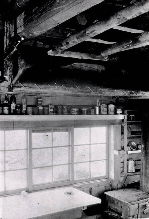 View shows bottles and canned good and portion of table and stove
