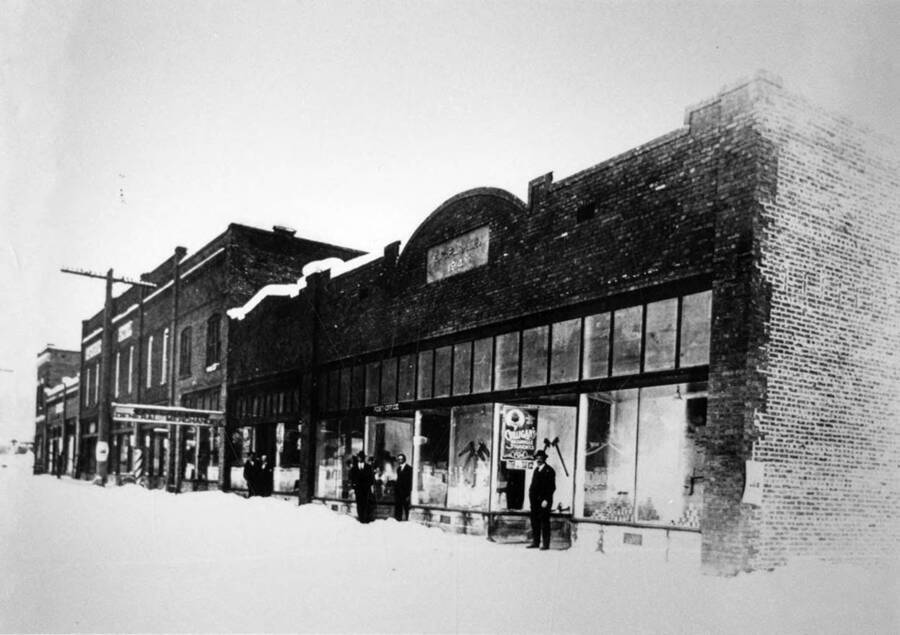 Bovill Main Street with people standing at the entrances of the stores.