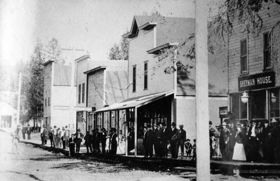 Bovill Main Street with people lining the street, standing in front of the stores.