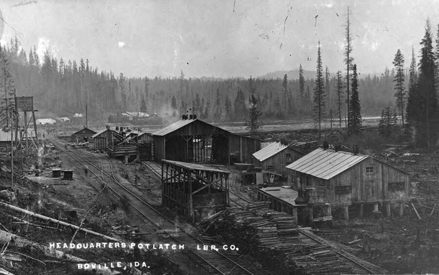 Potlatch Co. Headquarters with railroad tracks running through it and covered in logs.
