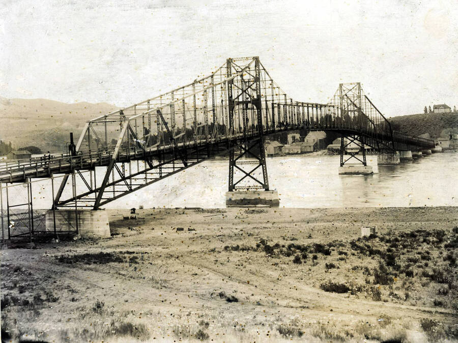 First Snake River bridge under construction'. Visible: Booth Flour Mill, Masonic Temple, C.P. Coburn shed and barn