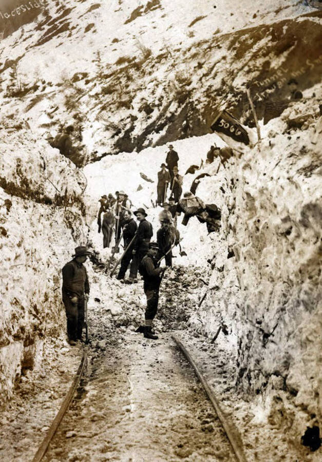 Men digging out railroad tracks after the snowslide. Mace, Idaho.