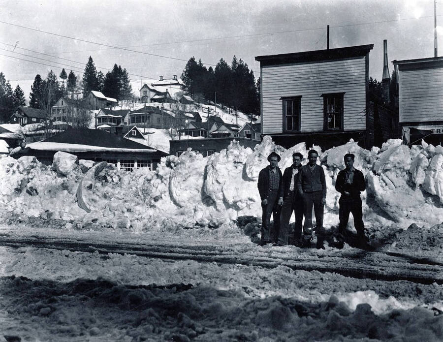Four men standing on Main Street in winter. Troy, Idaho.