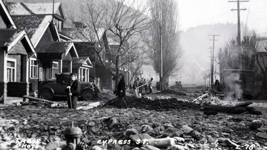 Cleaning up the destruction on Cypress Street from the Placer Creek Flood. Wallace, Idaho.