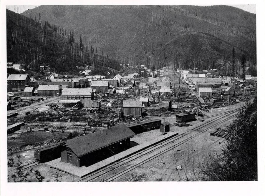 View of Wallace, Idaho with the Oregon Railroad and Navigation Company Depot and tracks in the foreground.