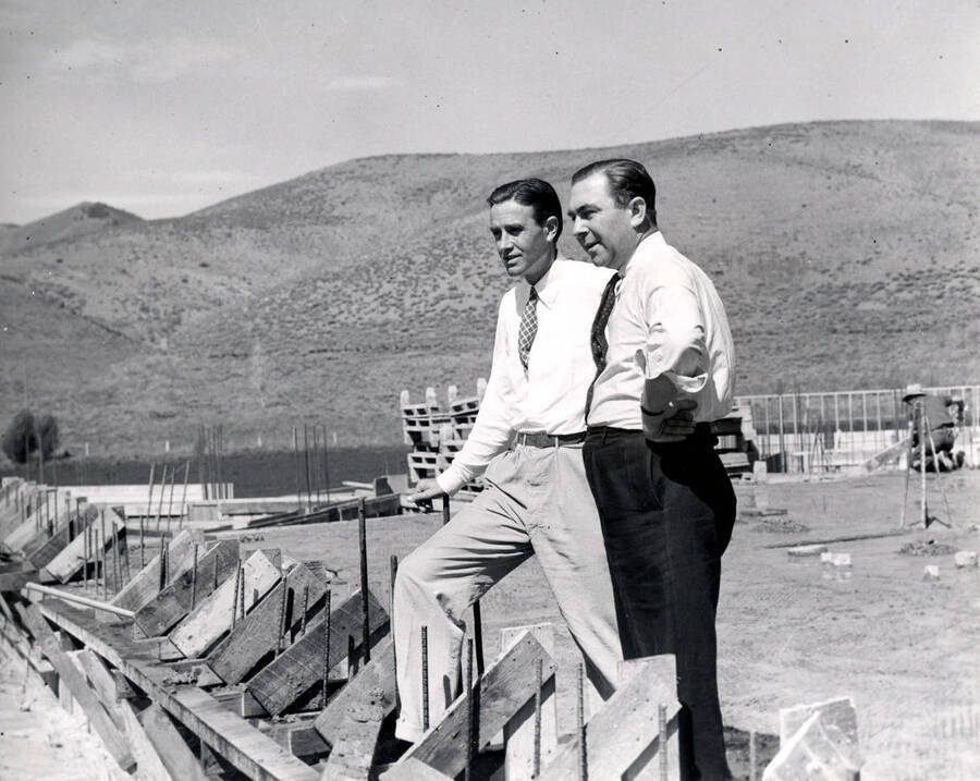 Darrell Harriman, founder, and Steve Hannegan, original publicity man, looking at lodge construction. Sun Valley, Idaho.
