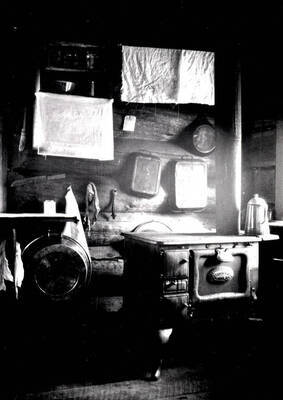 View shows kitchen stove, coffee pot, baking pans, dishpan and skillet