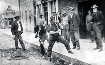 Two men working on the street, others watching. Challis, Idaho.
