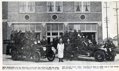 Standing in front in white coat is Carl Smith, fire chief.