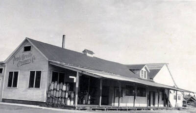Shows cream cans stacked on porch