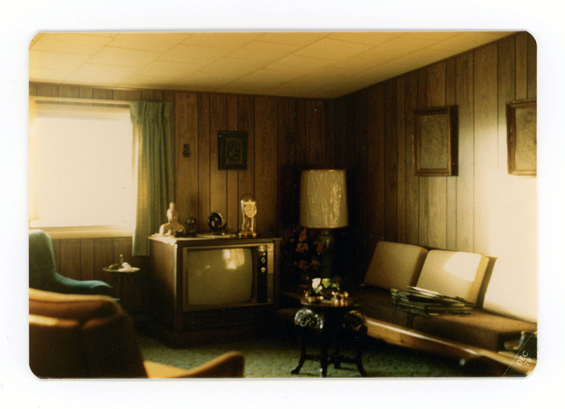 The front of a postcard decorated with a picture of an empty living room.