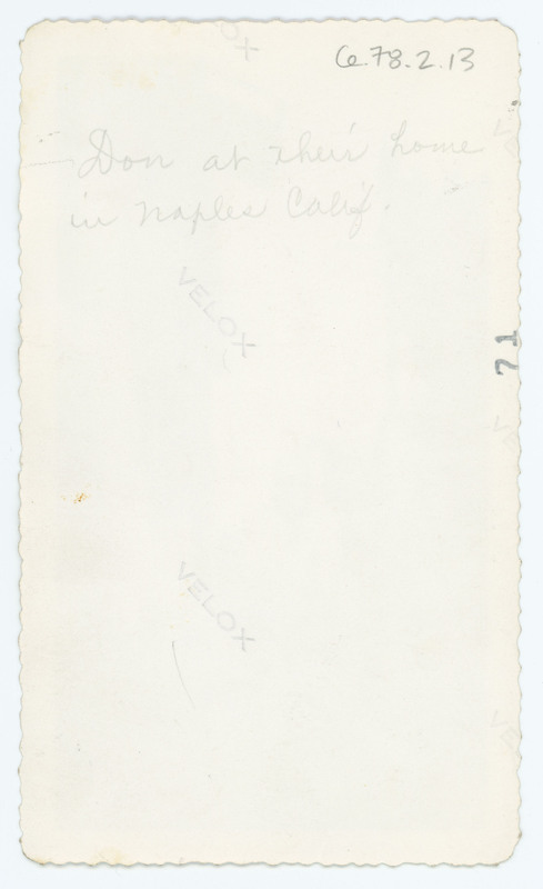 A note written on the back of the image Ce.78.1.13.1. The note states that the image is of Donald Crabtree sitting outside "their" home in Naples, California.