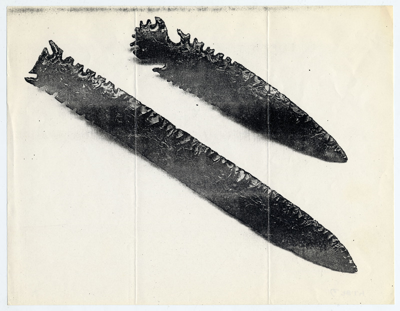 Two long obsidian points with intricate serration designs.