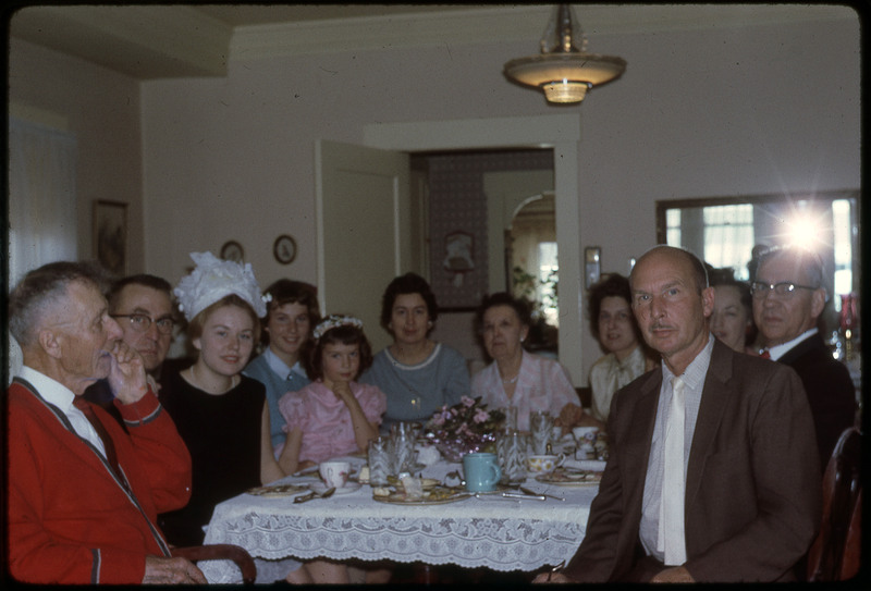 A photographic slide of a group of people having their photograph taken at a party.