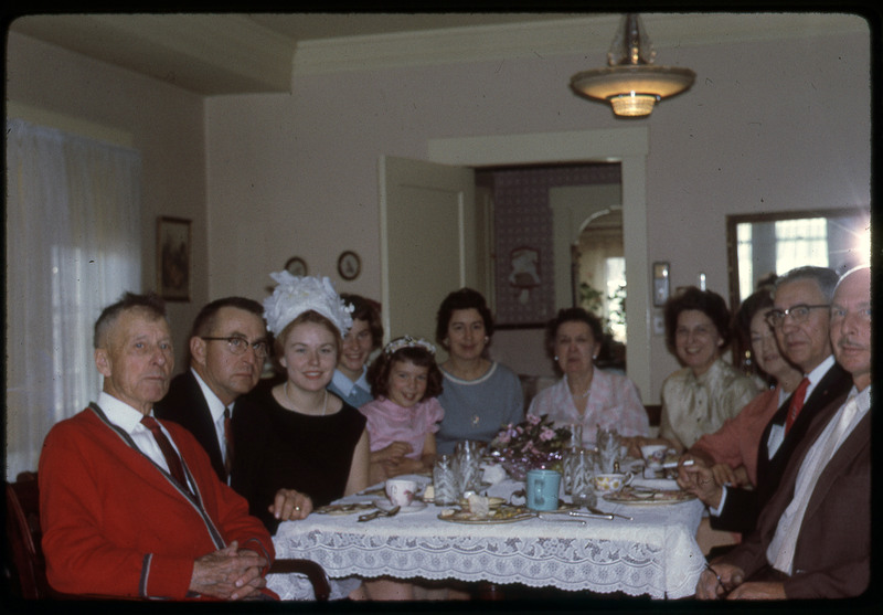 A photographic slide of a group of people having their photograph taken at a party.