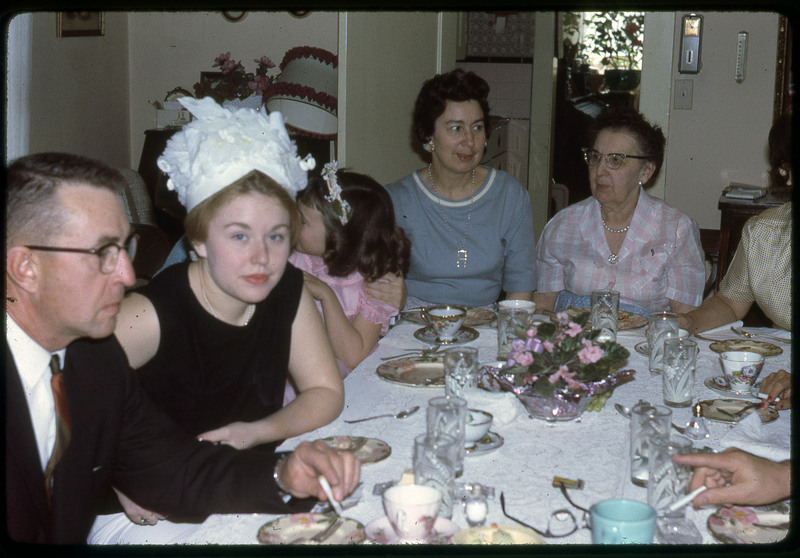 A photographic slide of a group of people having their photograph taken at a party.