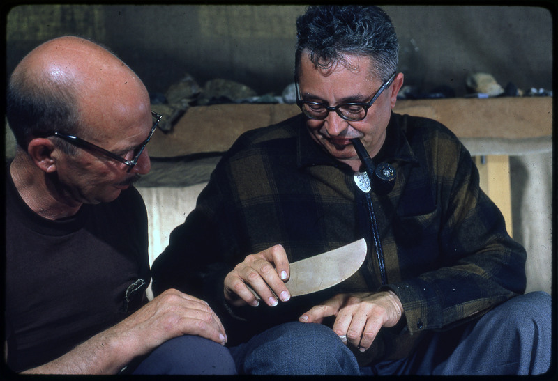 A photographic slide of Donald "Don" E. Crabtree and another man observing a lithic biface.