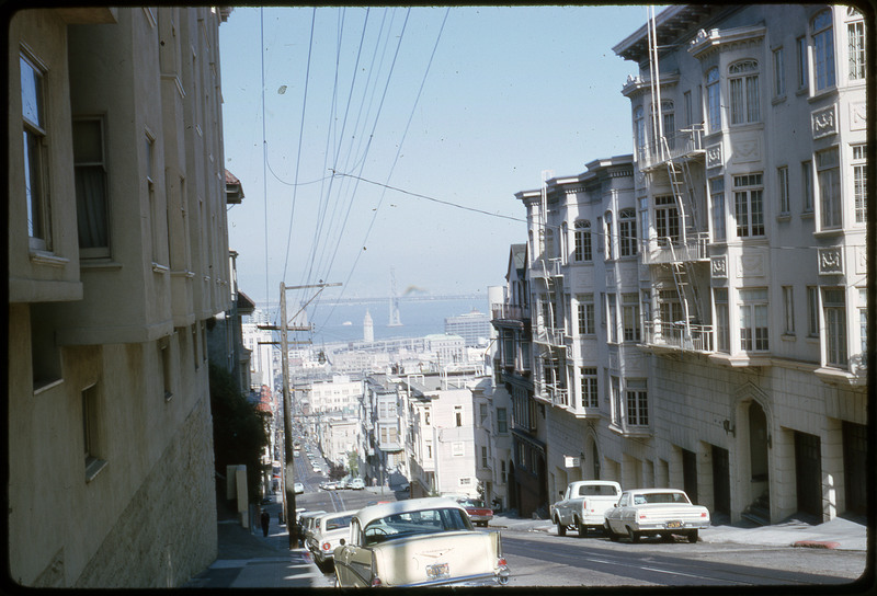 A photographic slide of a road extending through a series of apartments.