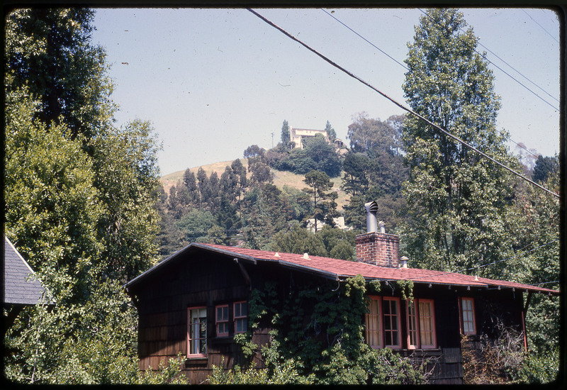 A photographic slide of a neighborhood surrounded by trees and greenery.