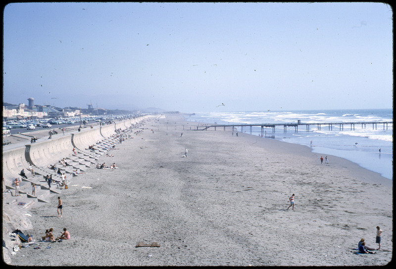 A photographic slide of a scenic view of a beach and pier.