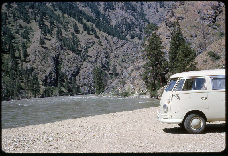 A photographic slide of a van on the shore of a river.