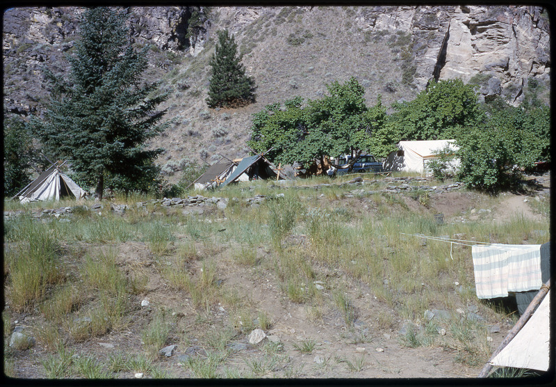 A photographic slide of a campsite in a verdant foothill.