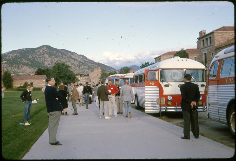 A photographic slide of groups of people leaving a set of busses.