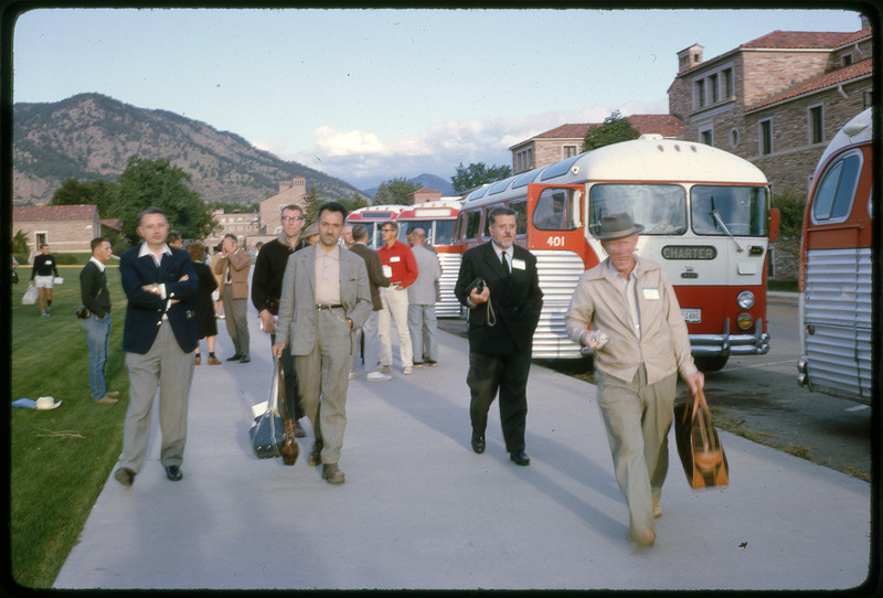 A photographic slide of groups of people leaving a set of busses.