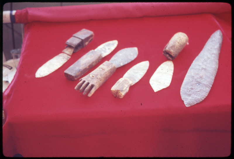 A photographic slide of a set of lithic tools displayed on red fabric.