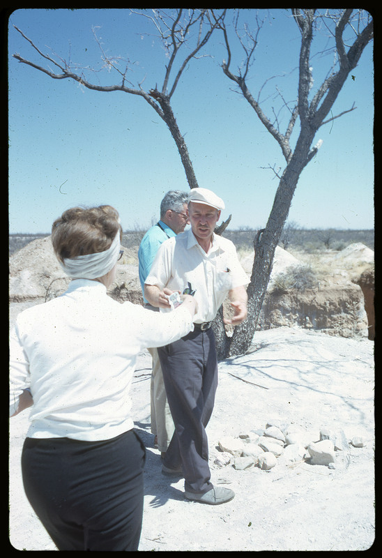 A photographic slide of Evelyn Crabtree giving Don E. Crabtree a pair of sunglasses in a desert.