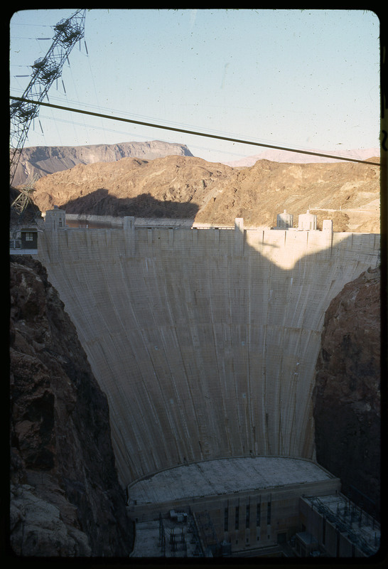 A photographic slide of a large dam covered in shade.