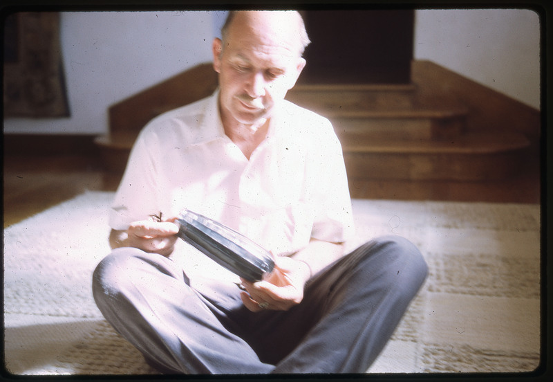 A photographic slide of a blurry view of Don E. Crabtree holding an obsidian core.