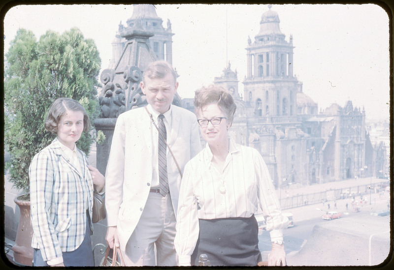 A photographic slide of two women and a man standing in front of an ornate stone cathedral.