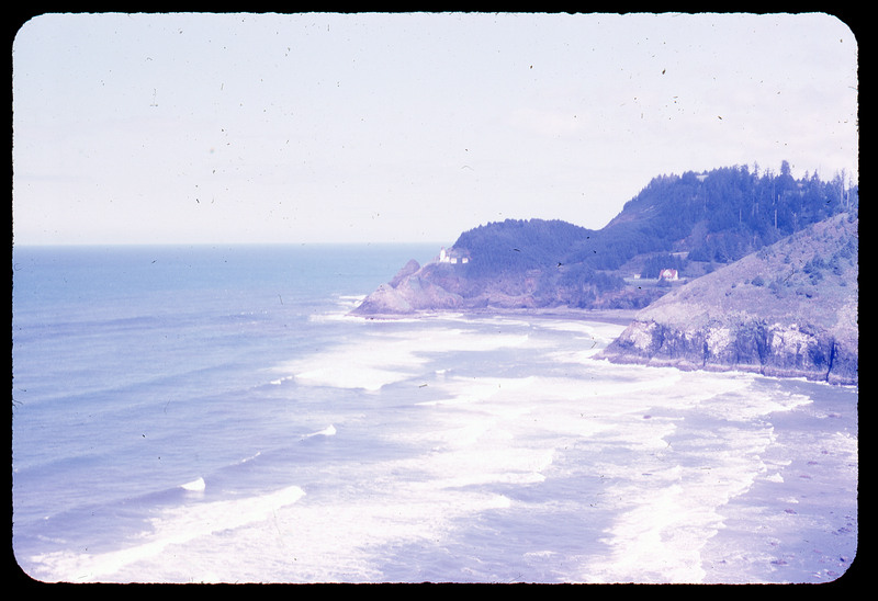 A photographic slide of a scenic view of ocean waves crashing on a sandy beach.