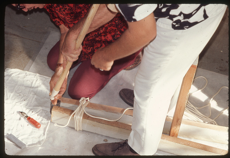 A photographic slide of Don E. Crabtree using a chest crutch to flintknap.