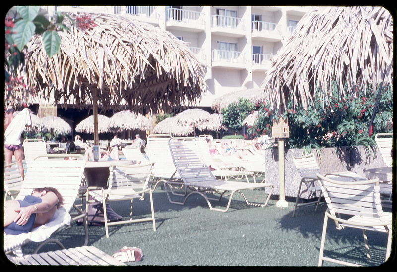 A photographic slide of a poolside filled with tourists.