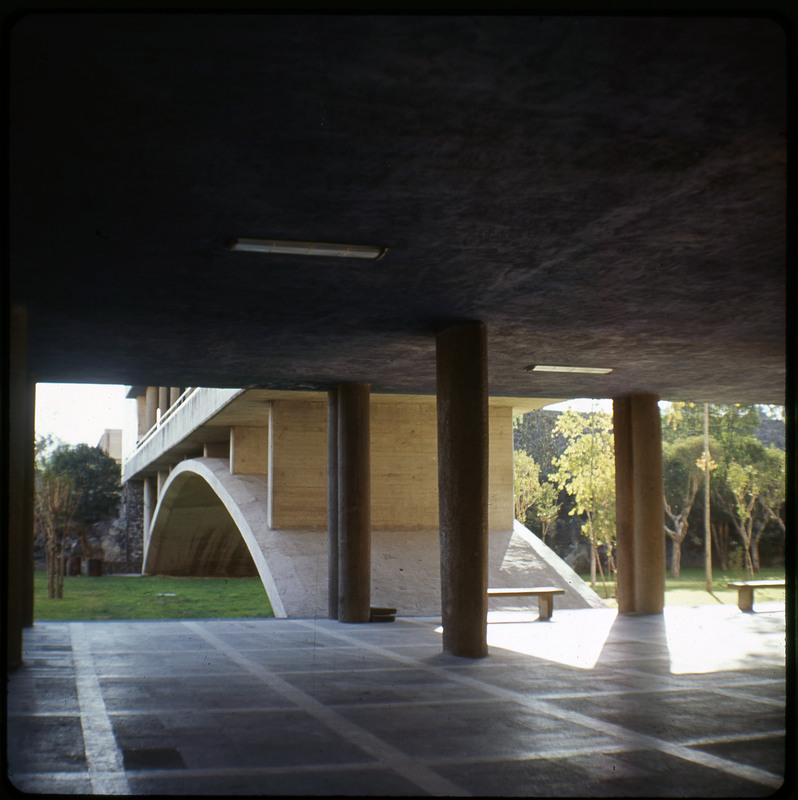 A photographic slide displaying the underside of the arch of a bridge. There are trees surrounding the arch.