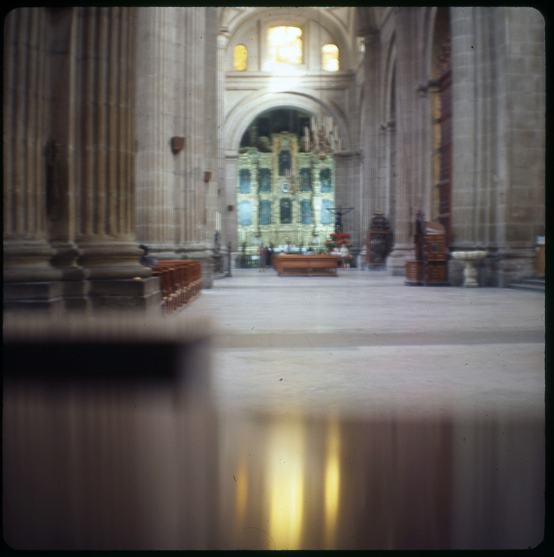 A photographic slide displaying the interior of a cathedral. Towards the back of the interior, there is a golden, ornamental structure.