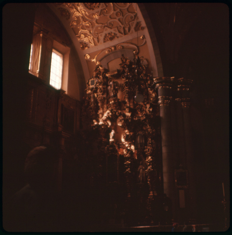 A photographic slide displaying an ornate fixture in a cathedral. The entire slide is tinted red.