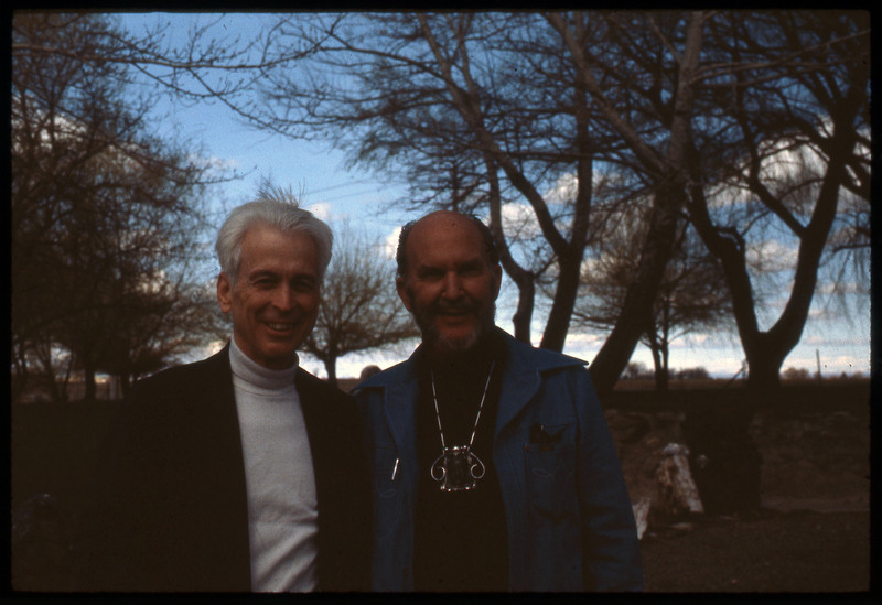 A photographic slide of Donald Crabtree standing next to a friend. Crabtree is wearing a unique necklace.