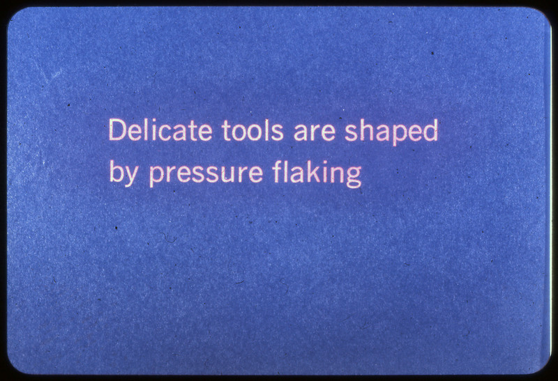 A photographic slide of a blue slide stating, "Delicate tools are shaped by pressure flaking."