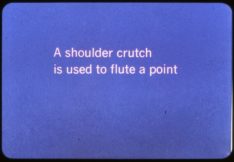 A photographic slide of a blue slide stating, "A shoulder crutch is used to flute a point."