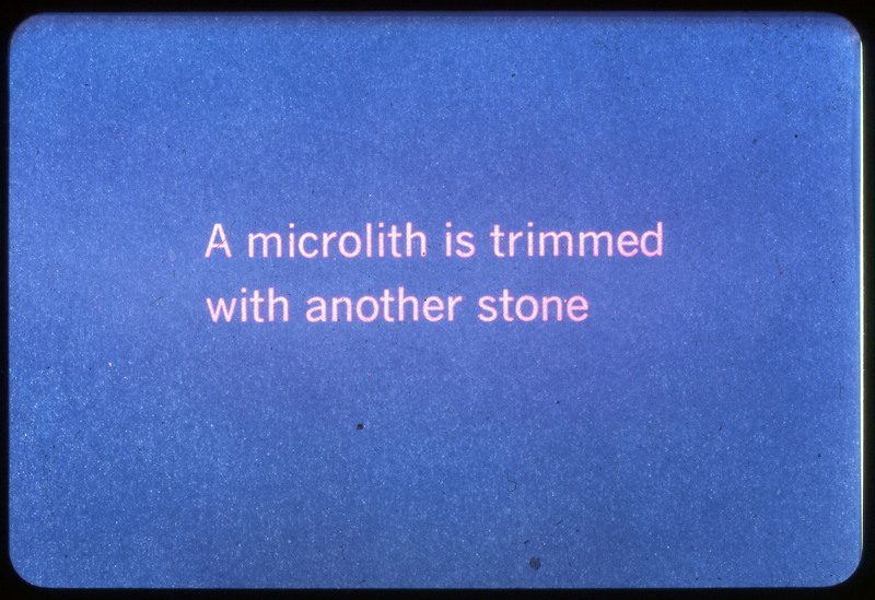 A photographic slide of a blue slide stating, "A microlith is trimmed with another stone."