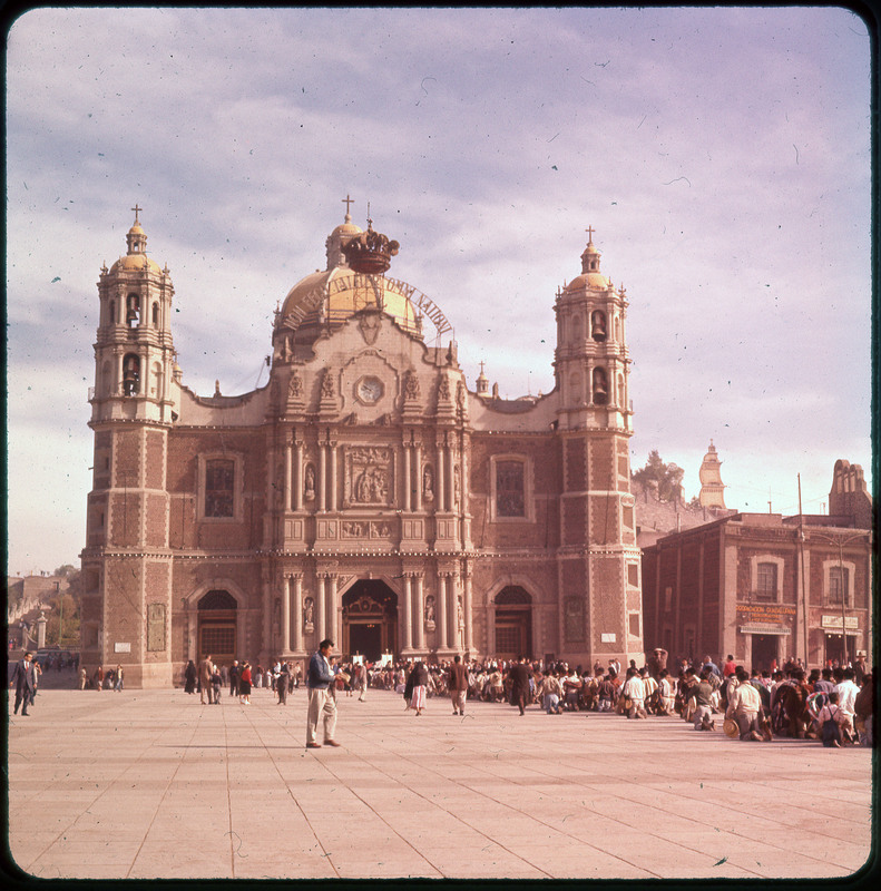 A photographic slide of Basilica of Our Lady of Guadalupe building with many people in a mass walking inside the building.