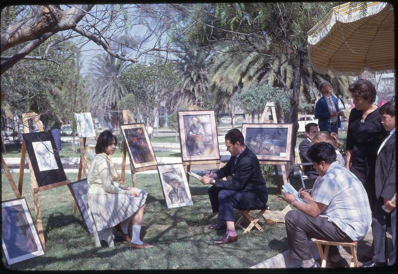 A photographic slide of a girl getting her portrait drawn by a variety of artists.